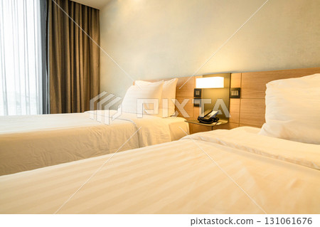 A double bed covered with white sheds in a beautiful bedroom. 131061676
