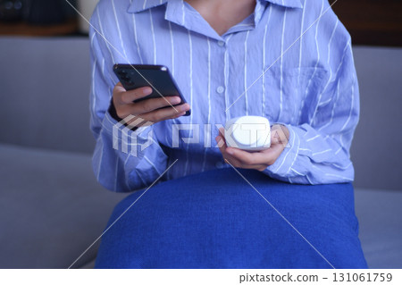 Young Asian women using phone checking on direction how to use vitamin supplementary, medicine before taking it. Young Asian women using phone checking on direction how to use vitamin supplementary, medicine before taking it. 131061759