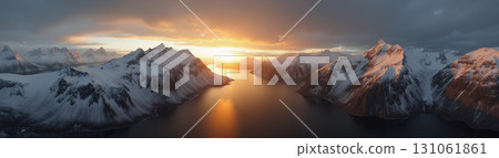 A beautiful northern landscape at sunset, with snow-covered mountains and a lake. 131061861
