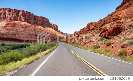 Empty scenic country road with stunning view of eroded red sandstone landscape in Utah, USA Empty scenic country road with stunning view of eroded red sandstone landscape in Utah, USA 131062039