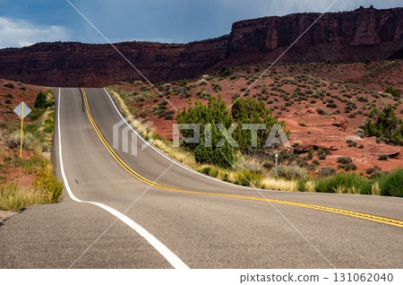 Empty scenic country road with stunning view of eroded red sandstone landscape in Utah, USA 131062040