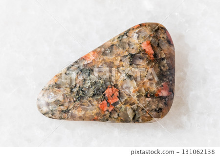 sample of tumbled gneissoid granite rock on white 131062138