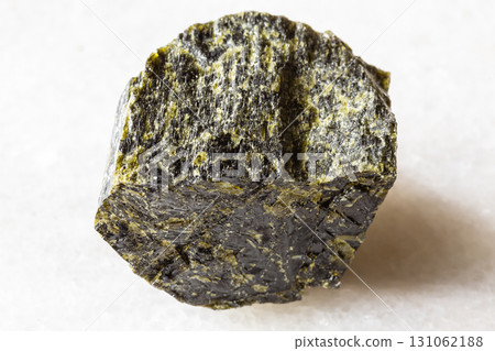 sample of rough diopside mineral on white marble 131062188