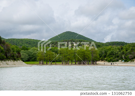 Mountain lake with cypress trees in cloudy weather. Sukko village, Anapa, Russia 131062750
