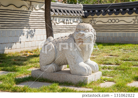 Korean Haechi statue at the entrance to Korea Garden Park. Stone guardian lion. Traditional Oriental Asian architecture. 131062822
