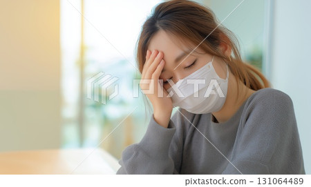 A sick Japanese woman wearing a mask 131064489
