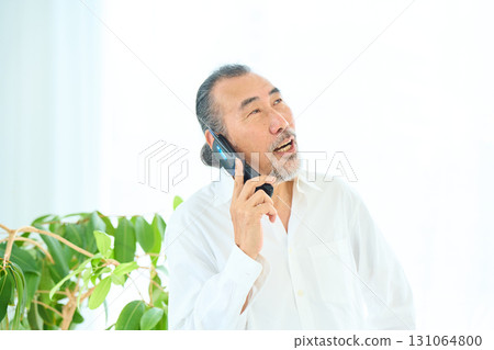 老人用翻蓋手機打電話 131064800