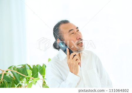 老人用翻蓋手機打電話 131064802