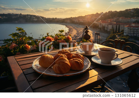 cup of coffee and french croissant on table, balcony with view of beautiful landscape, still life, sea and mountains, resort town, sunset 131065612