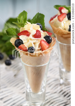 Japanese crepes with whipped cream filling, strawberries, blueberries, almond petals, garnished with mint. Japanese crepes with whipped cream filling, strawberries, blueberries, almond petals, garnished with mint. 131066010