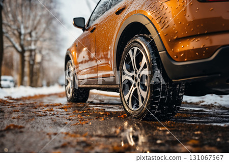 a car wheels on the background of a winter road and a beautiful landscape, a snow-covered forest, a concept of traffic safety on a slippery road 131067567