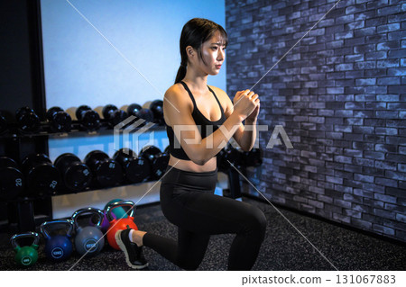 Split squats to train your buttocks, lunges, cool women exercising at the gym, hip-ups, muscle training girls 131067883