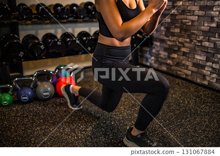 Split squats to train your buttocks, lunges, cool women exercising at the gym, hip-ups, muscle training girls 131067884