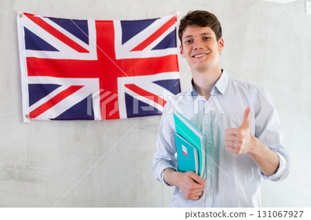 Young guy posing with notebooks against background of UK flag 131067927
