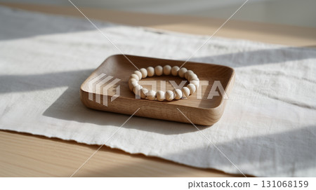 Minimalist beaded bracelet on wooden plate symbolizing mindfulness 131068159