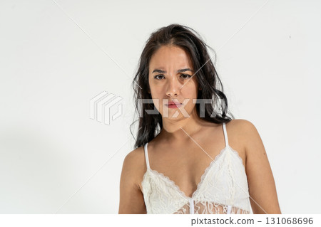 Serious young woman expressing doubt and disbelief on white background 131068696
