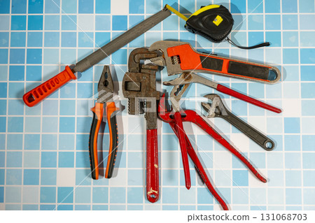 Plumbing tools lying on blue tiles ready for home improvement repairing Plumbing tools lying on blue tiles ready for home improvement repairing 131068703