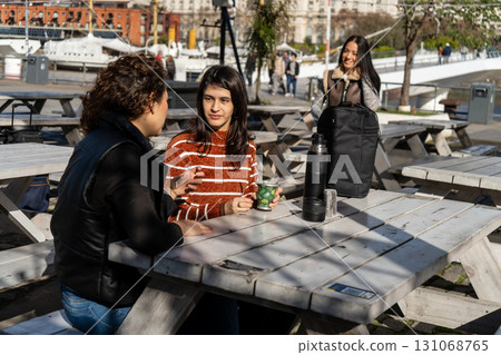Women talking and drinking coffee at outdoor tables in buenos aires 131068765