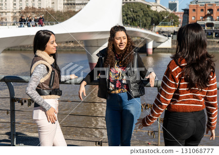 Young women talking next to the puente de la mujer in buenos aires, argentina 131068777