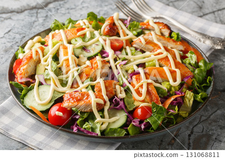 buffalo chicken salad with romaine, smattering of fresh vegetables and an irresistible buttermilk blue cheese dressing closeup on the plate. Horizontal buffalo chicken salad with romaine, smattering of fresh vegetables and an irresistible buttermilk blue cheese dressing closeup on the plate. Horizontal 131068811