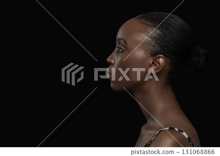 Side Profile Portrait of Young Black Woman on Dark Background Side Profile Portrait of Young Black Woman on Dark Background 131068866