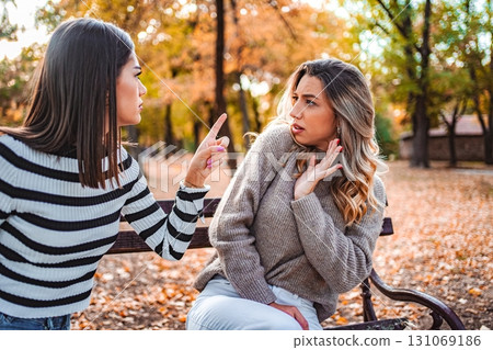 Girls share a heartfelt talk in an autumn park of colorful leaves Girls share a heartfelt talk in an autumn park of colorful leaves 131069186