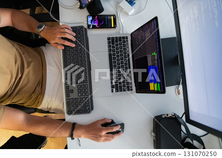 Top view of programmer diligently testing smartphone applications while sitting in their office. 131070250