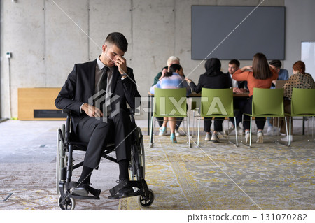 A sad and disheartened director in a wheelchair sitting alone in a large office, reflecting on the challenges and isolation that come with their professional responsibilities A sad and disheartened director in a wheelchair sitting alone in a large office, reflecting on the challenges and isolation that come with their professional responsibilities 131070282