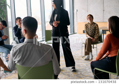Corporate business team meeting with a manager or coach. Group of happy diverse, multiracial people sitting in a circle  131070438