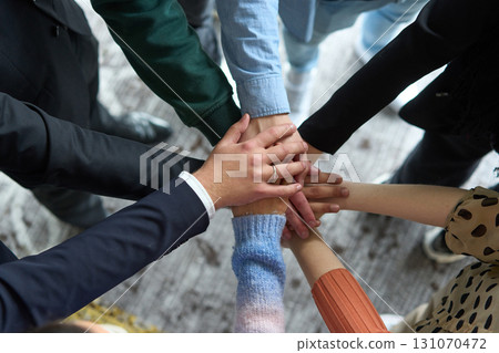 A top view of business people joining hands in a circle, symbolizing unity, collaboration, and shared success in the workplace A top view of business people joining hands in a circle, symbolizing unity, collaboration, and shared success in the workplace 131070472