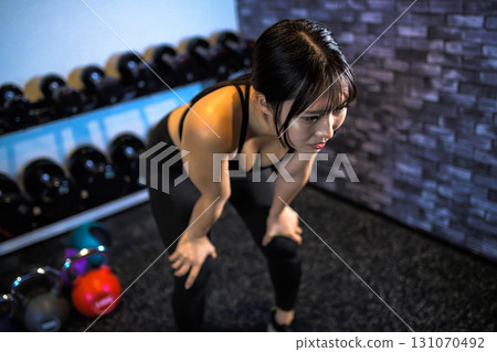 Tired woman taking a break, fatigue, cool woman exercising at the gym, muscle training girl 131070492