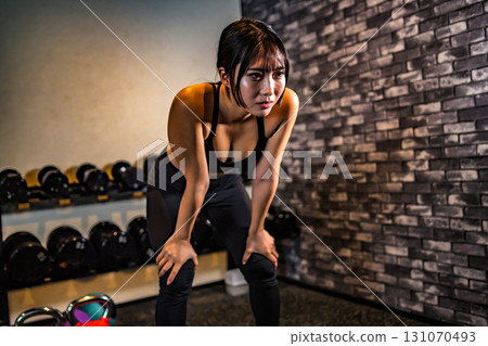 Tired woman taking a break, fatigue, cool woman exercising at the gym, muscle training girl 131070493