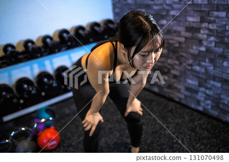 Tired woman taking a break, fatigue, cool woman exercising at the gym, muscle training girl 131070498