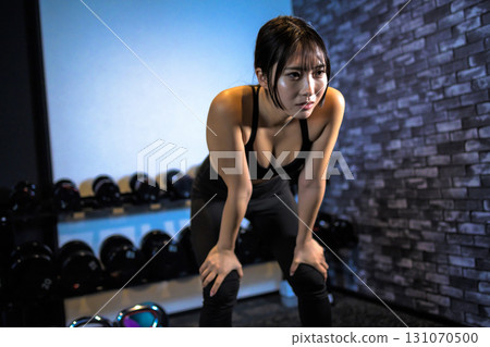 Tired woman taking a break, fatigue, cool woman exercising at the gym, muscle training girl 131070500