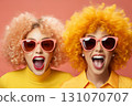 portrait of two fashionable girls with hair and glasses, surprised, in bright yellow clothes, on a pink background 131070707