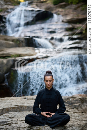 A woman sits in lotus pose, practicing yoga and tai chi under a tropical waterfall, meditating with calm strength and mindfulness, fully connected to the energy of nature, tranquility and inner A woman sits in lotus pose, practicing yoga and tai chi under a tropical waterfall, meditating with calm strength and mindfulness, fully connected to the energy of nature, tranquility and inner 131070752