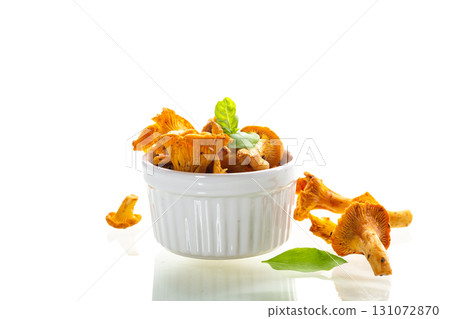 Chanterelles in a white bowl on a white background Chanterelles in a white bowl on a white background 131072870