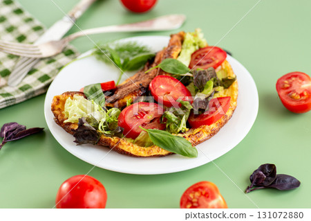Golden omelette with salad mix and spicy aroma on top 131072880