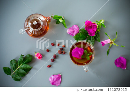 Homemade rosehip and mint tea in a transparent cup and teapot Homemade rosehip and mint tea in a transparent cup and teapot 131072915