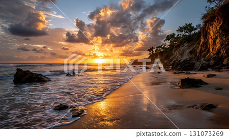 Dramatic Beach Sunset with Clouds, Cliffside, and Golden Light Reflections on Water 131073269