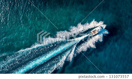White Motorboat Cruising Turquoise Ocean Water, Aerial View of Boat and Wake White Motorboat Cruising Turquoise Ocean Water, Aerial View of Boat and Wake 131073557