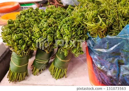 Paku midin or bidin fern, a traditional and popular vegetable in Sarawak, being sold in market stall 131073563