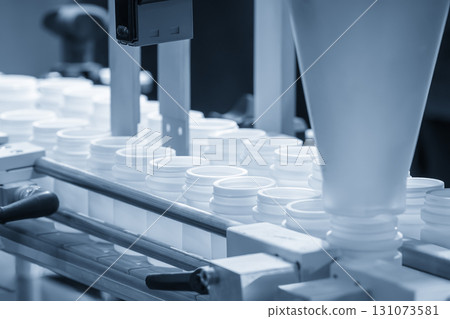 The drug bottle filling process by automatic system in the light blue scene. 131073581
