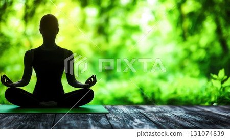 Serene Silhouette of Woman Meditating in Nature Surrounded by Lush Greenery 131074839