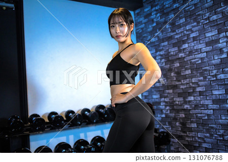 Posing well-trained woman, cool woman exercising at the gym, back muscles, hip up, muscle training girl 131076788
