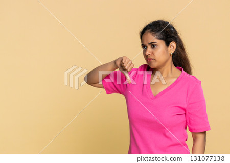 Indian woman disappointed showing thumbs down gesture, expressing disagreement and dissatisfaction 131077138