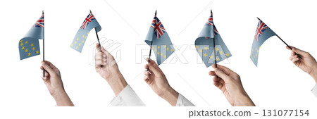 The Tuvalu flag in hand in different angles on a white background The Tuvalu flag in hand in different angles on a white background 131077154