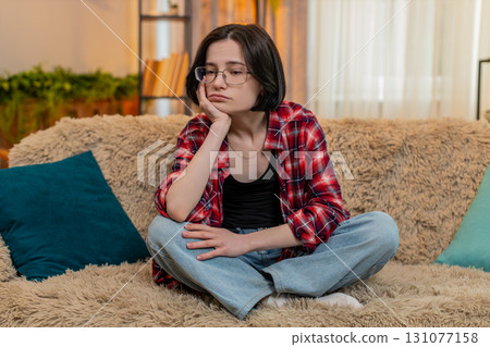 Woman sitting with sad face at home, thinking quietly about personal stress and difficult problem Woman sitting with sad face at home, thinking quietly about personal stress and difficult problem 131077158