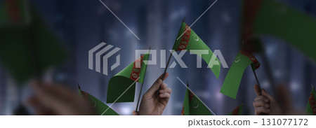 Turkmenistan flags in their hands on a blurred urban background Turkmenistan flags in their hands on a blurred urban background 131077172