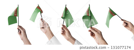 The Turkmenistan flag in hand in different angles on a white background 131077174